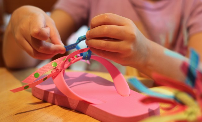 Tying the ribbon around the flip flop straps